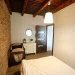 Przytulna sypialnia w domku na Kaszubach z podwójnym łóżkiem, łóżeczkiem dziecięcym, lustrem i sufitem z drewnianymi belkami