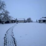 Zaśnieżony krajobraz Kaszub z kilkoma domkami i ścieżką przez śnieg